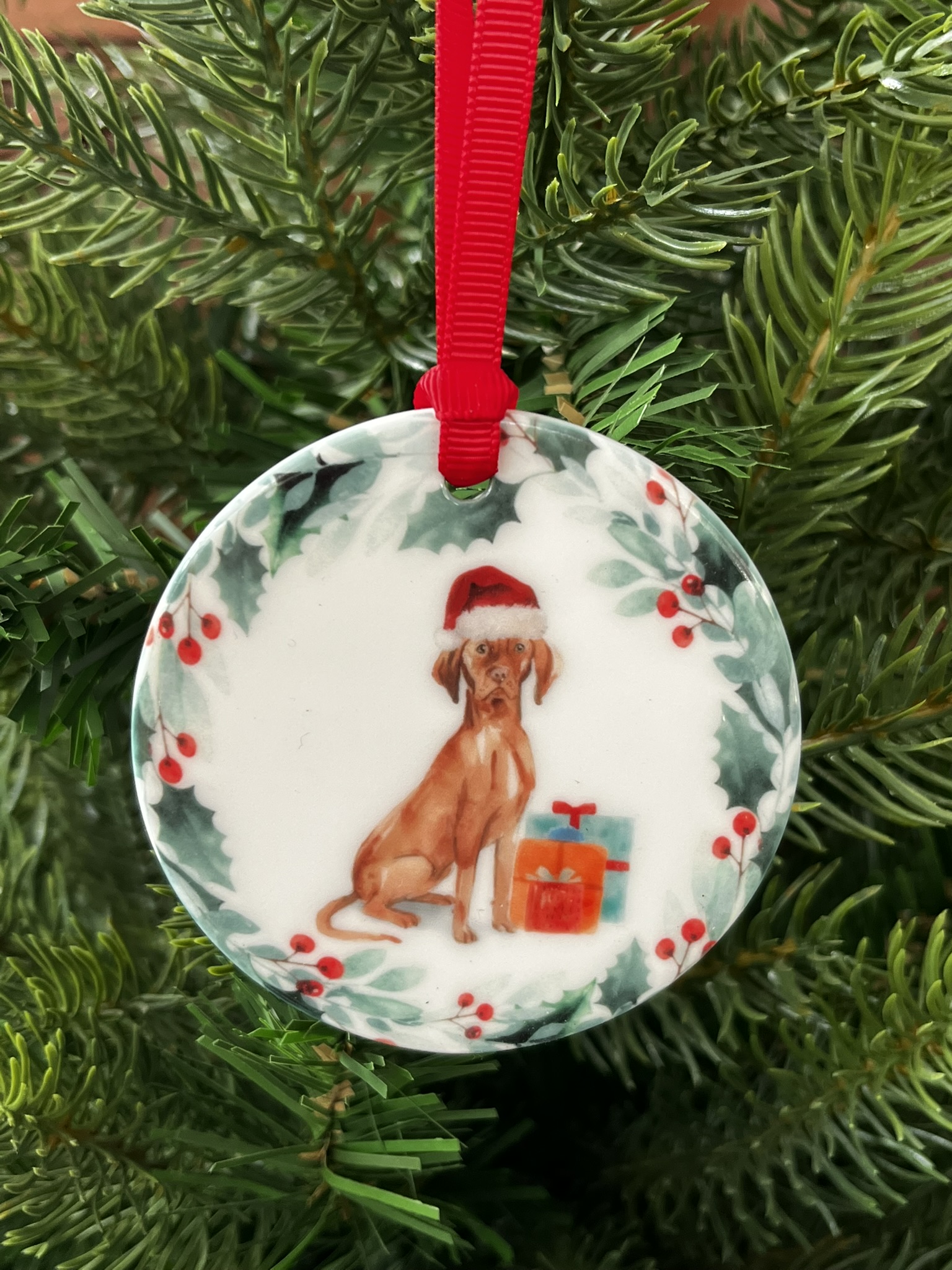 Ceramic hanging decoration. An image of a Hungarian Vizla wearing a Christmas hat