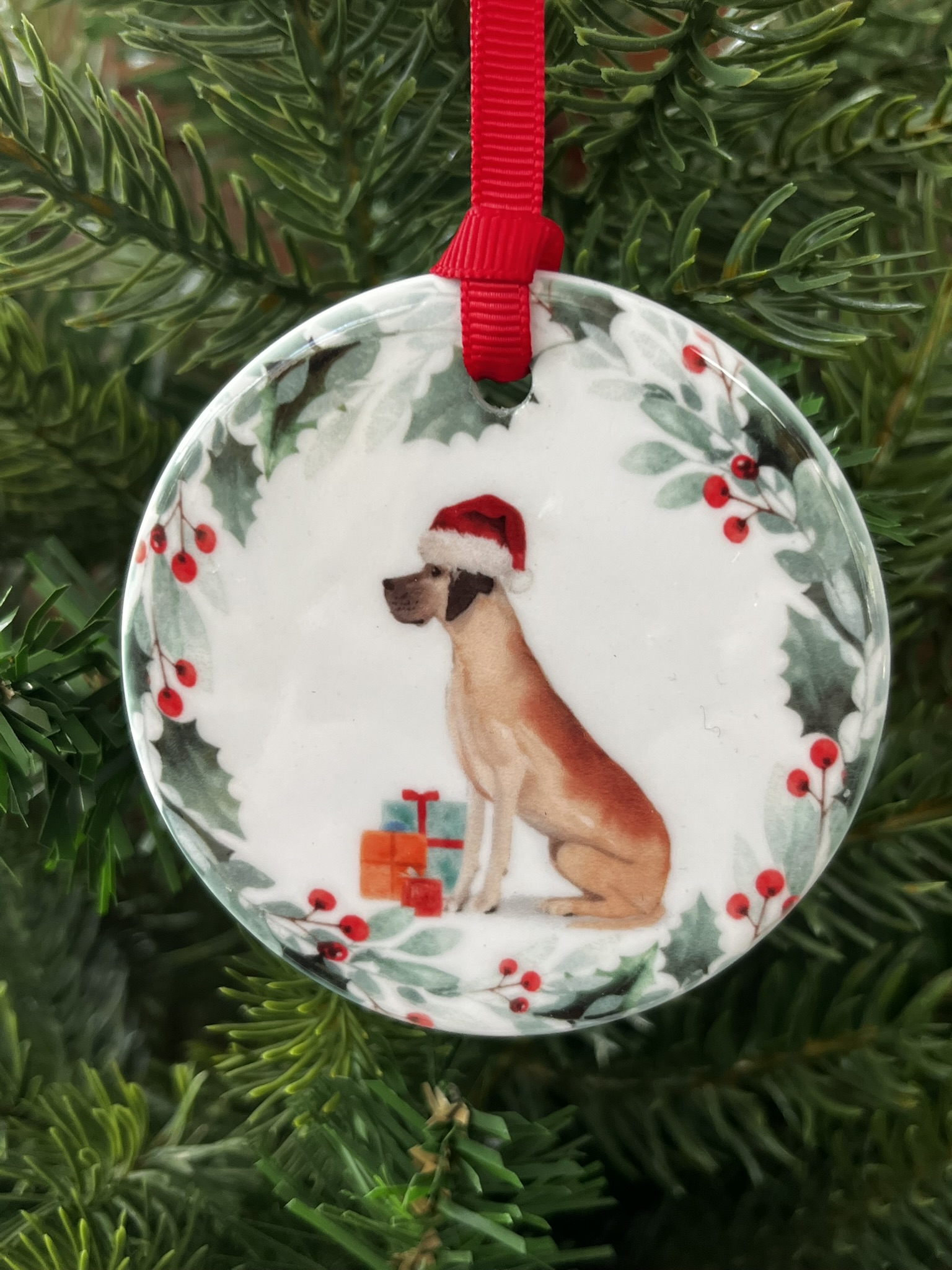 Ceramic hanging decoration. An image of a Great Dane wearing a Christmas hat.