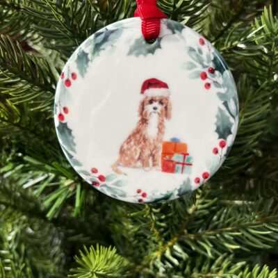 Ceramic hanging decoration with an image of a Cavapoo wearing a Christmas hat