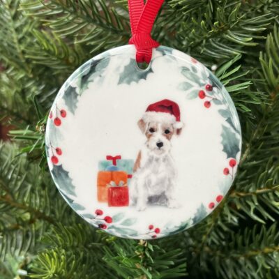 Ceramic hanging decoration. An image of a long haired Jack Russell wearing a Christmas hat